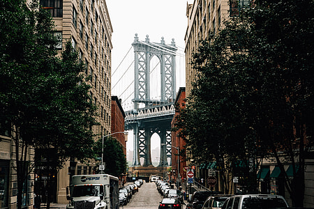 cars parked on road between high rise building under bridge background thumbnail
