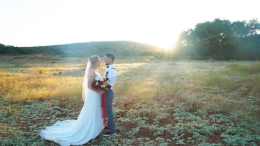 groom and bride facing each other on grassfield thumbnail