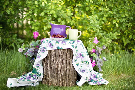 two purple and yellow ceramic cup and pitcher on multicolored floral textile thumbnail