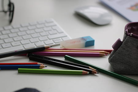 Shallow Focus Photography of Assorted Pencils Near Apple Keyboard and Mouse thumbnail