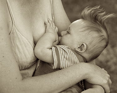 sepia photo of woman breast feeding baby thumbnail