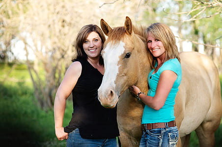 two women standing beside a horse thumbnail