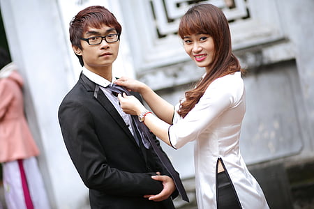 woman holding fixing man's necktie thumbnail