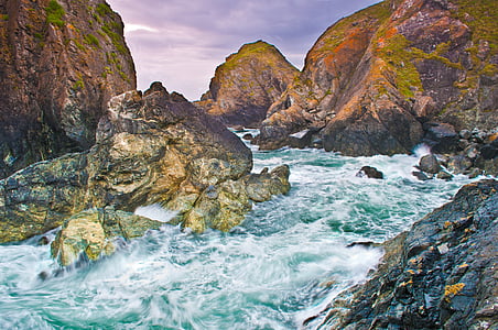 silky water photo of waves crashing on rocky shore during twilight thumbnail
