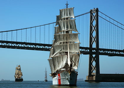 gray and red pirate ship near bridge at daytime thumbnail