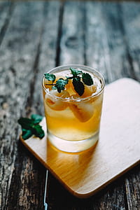 clear drinking glass filled with yellow liquid thumbnail