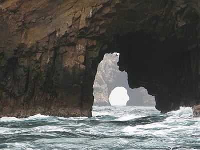 body of water under the shade of rock formation thumbnail
