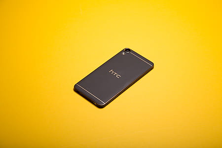 black HTC Desire 820 smartphone on yellow surface thumbnail