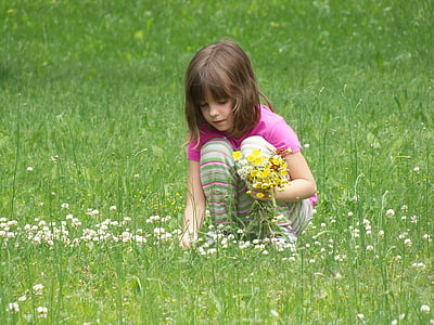 photo of girl picking up flowers in field thumbnail