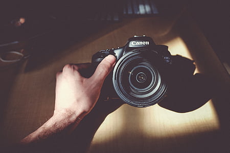 person holding black Canon EOS camera thumbnail