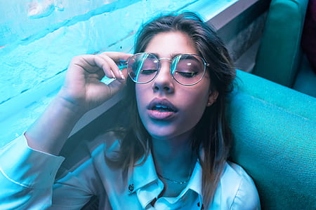 woman looking up while holding her eyeglasses thumbnail