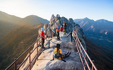 several people standing near stone cliff thumbnail