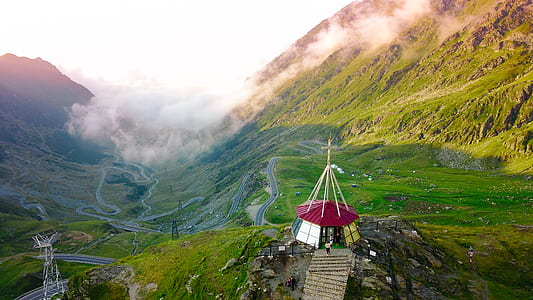 aerial photography of white and red tent on green valley thumbnail