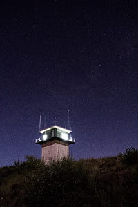 white tower post during nighttime thumbnail