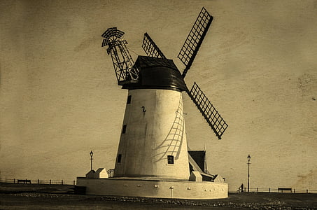 white windmill beside shore thumbnail
