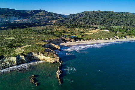 island near seashore under blue sky thumbnail