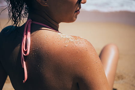 Sandy shoulder of a caucasian woman sunbathing on the beach thumbnail