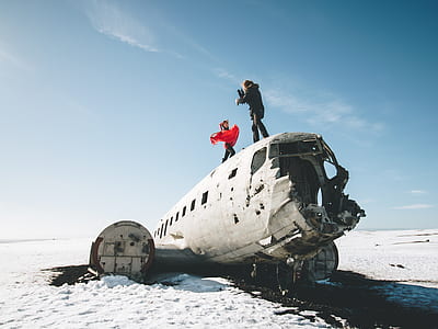 two people standing on top of airplane under blue sky thumbnail