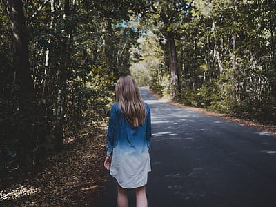 Woman Wearing Blue and White Long-sleeved Shirt Walking Near Tree thumbnail
