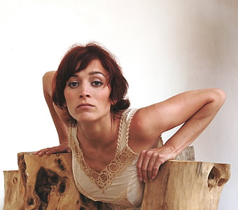 woman laying her hand on trunk bending her back towards trunk thumbnail
