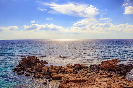 calmly ocean under blue and cloudy sky at daytime thumbnail