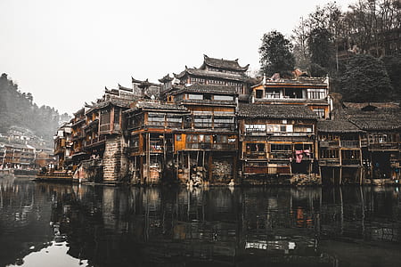 black and brown wooden house on body of water thumbnail