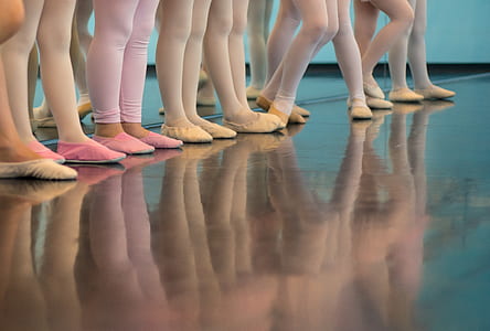 ballerinas wearing leggings and shoes reflecting on wood floor thumbnail