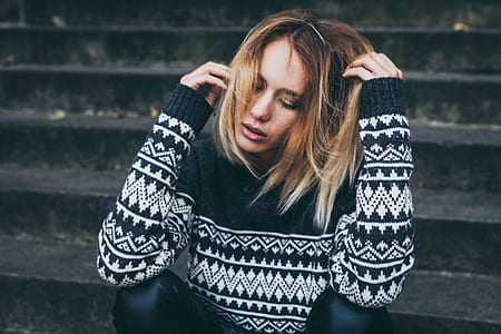 woman wearing black and white sweater sitting on stair thumbnail