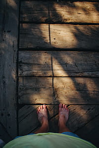 person standing on brown wooden floor thumbnail