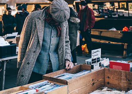 person standing beside books on table thumbnail