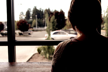 woman sitting in front of table near window thumbnail
