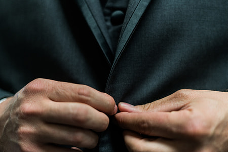 man holding on clothes button thumbnail