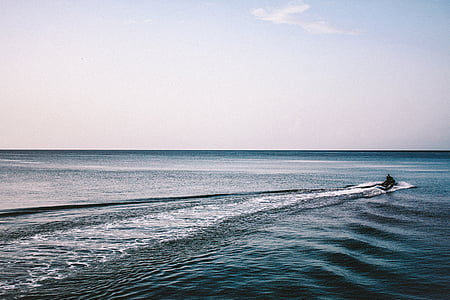 silhouette of man riding personal watercraft during daytime thumbnail