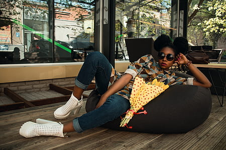 Woman Lying on Black Bean Bag Chair Near Cafe thumbnail
