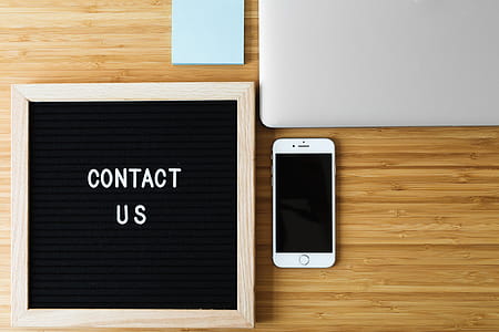 Contact Us Sign With Phone On Desk Photo thumbnail