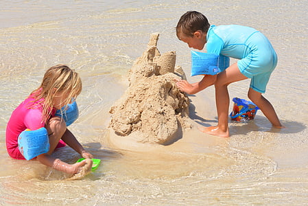 boy and girl build sand castle thumbnail