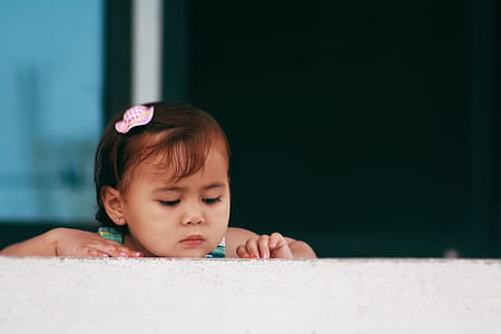 selective focus photography of girl leaning on wall thumbnail