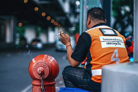 man in orange top sitting on blue flooring thumbnail