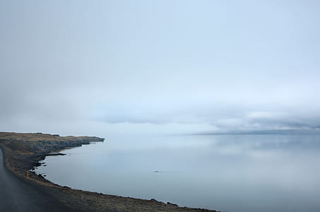 calm body of water under white sky at daytime thumbnail