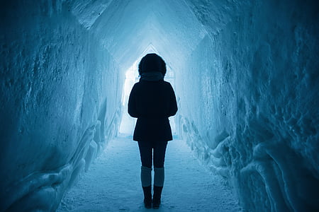 person in winter jacket standing inside the ice cave thumbnail
