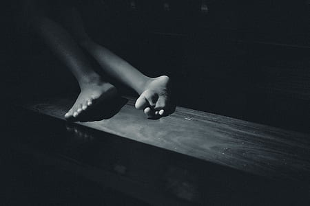 grayscale photo of person lying on wooden surface thumbnail