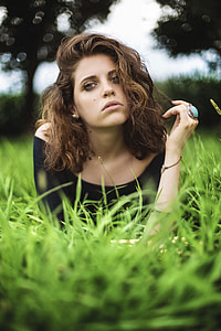 selective focus photography of woman in black boat neckline shirt lying on ground thumbnail