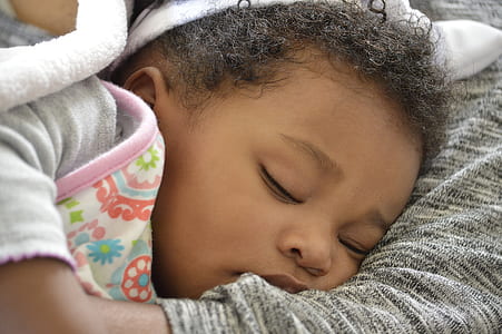 girl lying on gray and black textile thumbnail