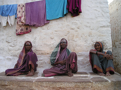 three women sitting on concrete floor thumbnail