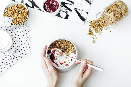 Person Mixing Cereal, Milk, and Strawberry Jam on White Ceramic Bowl thumbnail