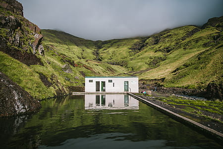 An outdoor mineral swimming pool in green mountains covered with clouds thumbnail