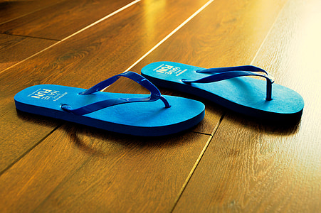 close-up photo of pair of teal flip-flops on floor thumbnail