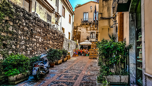white and black motor scooter beside plant near people sitting under canopy at daytime thumbnail