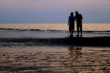couple standing on seashore thumbnail