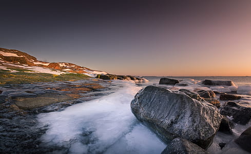 gray rocks with body of water under gray sky during daytime thumbnail